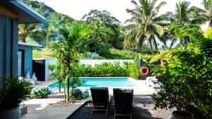 a backyard with a swimming pool and palm trees at Casa Del Sol in Rarotonga