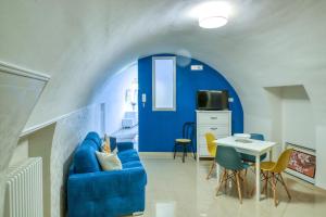 uma sala de estar com um sofá azul e uma mesa em La Cattedrale Apartments&Suite - Affitti Brevi Italia em Gravina in Puglia