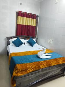a bedroom with a bed with a towel on it at V1 Stay Home in Tirupati
