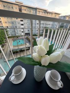 un vase avec des fleurs blanches sur une table sur un balcon dans l'établissement Trees Marias Affordable Staycation in Quezon City, à Manille