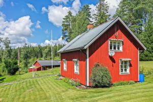 奧莫爾的住宿－schwedischer Waldhof -Marie- in einsamer Lage，红谷仓,位于郁郁葱葱的绿色田野上