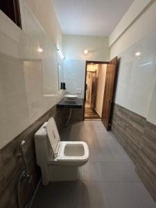 a bathroom with a toilet and two sinks in it at Hotel Royal Orbit in Dehradun
