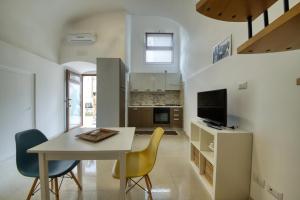 Una cocina y un comedor con mesa y sillas. en La Cattedrale Apartments&Suite - Affitti Brevi Italia, en Gravina in Puglia