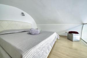 Dormitorio con cama con almohada morada en La Cattedrale Apartments&Suite - Affitti Brevi Italia, en Gravina in Puglia