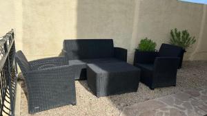 two wicker chairs and a table and chairs on a patio at En route pour disney et shopping a la vallée village in Couilly-Pont-aux-Dames