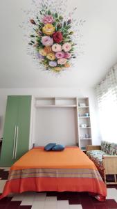 Zimmer mit einem Bett mit Blumenarrangement an der Decke in der Unterkunft L' Appoggio - Monolocale Eco-sostenibile A Due Passi Dal Centro Storico in Corsano