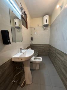 a bathroom with a sink and a toilet at Hotel Royal Orbit in Dehradun