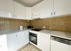 a white kitchen with white cabinets and a sink at En route pour disney et shopping a la vallée village in Couilly-Pont-aux-Dames +5 photos