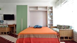 Zimmer mit einem Bett, einem Schreibtisch und einem TV in der Unterkunft L' Appoggio - Monolocale Eco-sostenibile A Due Passi Dal Centro Storico in Corsano