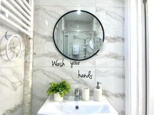 bagno con lavandino e specchio di Nice and Cosy Large Studio near Luton Airport a Luton
