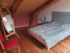 a bedroom with a bed and a chair in a attic at " gite Au Pied Du Chapelas" in Le Plagnal