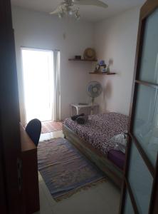 Habitación pequeña con cama y ventana en Swieqi Apartment, en San Julián