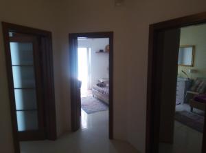 a hallway with two doors and a room with a bed at Swieqi Apartment in St. Julianʼs