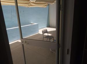 una silla sentada en una habitación con ventana en Swieqi Apartment, en San Julián