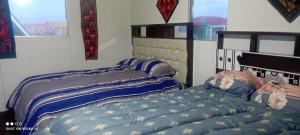 Duas camas sentadas uma ao lado da outra num quarto em casa ecológica em Puno