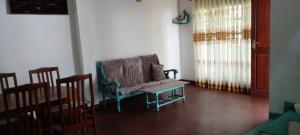 a living room with a couch and a table and chairs at The Home in Weligama