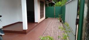 a porch of a house with a green fence at The Home in Weligama