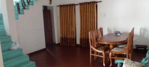 a dining room with a wooden table and chairs at The Home in Weligama +8 photos