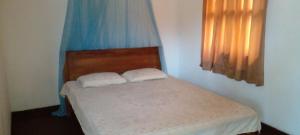 a bedroom with a bed with two white pillows at The Home in Weligama