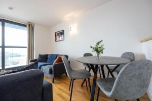 a living room with a table and chairs and a couch at Stunning Duplex Apartment, Free Parking For 2, WI-FI, Central Location, Long Term Disc in Manchester