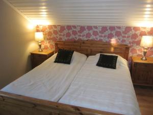 Huldas gård villa med självhushåll في Kumla: سريرين في غرفة نوم مع مصباحين على الطاولات