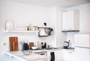 a kitchen with white cabinets and a counter top at New White Studio F next to Forest the Gondola in Bansko +6 photos
