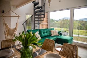 sala de estar con sofá verde y mesa en Beskid Sielski - klimatyczne domki w Lipowej z widokiem na góry i sauną - Dream Apart en Żywiec