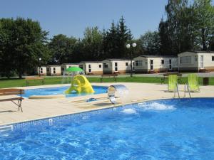 a swimming pool with a slide in a park at Hotel Górecki in Lidzbark Warmiński