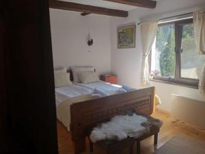 um quarto com uma cama grande e uma janela em Майоровата къща em Shiroka Lŭka