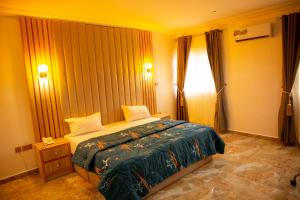 a bedroom with a bed and a window at Cogent Apartments Single Rooms in Uyo