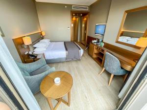 a hotel room with a bed and a table and chairs at Holiday Inn Bursa - City Centre by IHG in Bursa