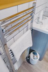 a bathroom with a sink and a toilet and a towel at Goodwin House in Keswick