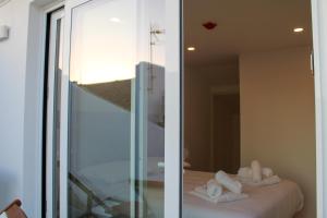 Habitación con espejo y toallas en la cama en Casa dos Cucos, en Ericeira