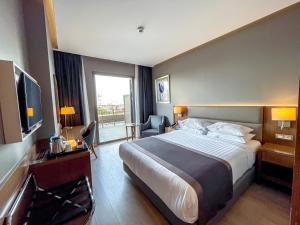 a hotel room with a large bed and a television at Holiday Inn Bursa - City Centre by IHG in Bursa