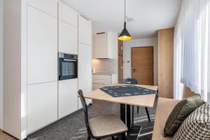 a small kitchen and dining room with a table and chairs at Mountain Meadows Apt 2 in Valdaora