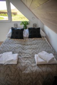 una camera da letto con un letto grande con due asciugamani sopra di Beskid Sielski - klimatyczne domki w Lipowej z widokiem na góry i sauną - Dream Apart a Żywiec