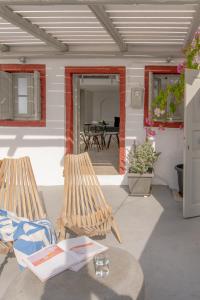 a patio with two wooden benches and a table at Kampanario Luxury Villa in Megalochori