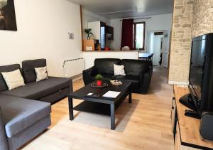a living room with a couch and a coffee table at "Colbert Triplex" 3 chambres - Balcon - Patio - Cathédrale in Tours