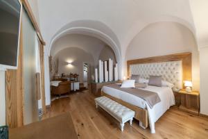 グラヴィーナ・イン・プーリアにあるIL Borgo Relaisの大きなベッドルーム(大型ベッド1台、ソファ付)