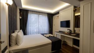 a hotel room with a bed and a television at Mai İnci Otel in Antalya