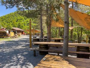 a group of picnic tables with trees in a park at Rifugio Nido del Biancone in Bosio