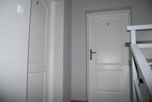 a white door in a room with a ladder at Domek nad Muszynką in Muszyna