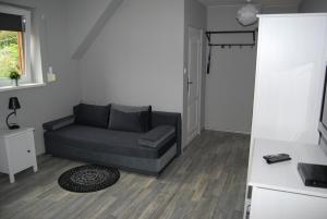 a living room with a couch and a table at Domek nad Muszynką in Muszyna