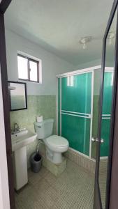 a bathroom with a toilet and a sink and a shower at The Wave Hostel Corn Island in Corn Islands