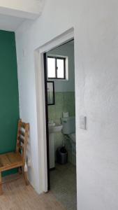 a bathroom with a toilet and a sink and a window at The Wave Hostel Corn Island in Corn Island