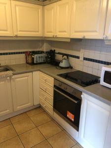 a kitchen with white cabinets and a stove top oven at Connolly Private Guest House in Dublin