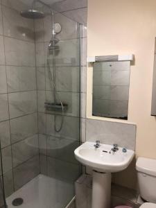 bagno con doccia, lavandino e servizi igienici di Connolly Private Guest House a Dublino