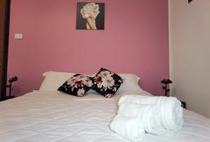 uma cama branca com duas almofadas em cima em Luxury Sisters House "La Buganvilla" em Catânia
