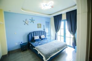 a blue bedroom with a bed and a window at Villa NovaWorld Phan Thiết - Bình Thuận in Phan Thiet