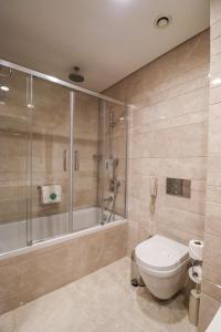 a bathroom with a shower and a toilet and a tub at Holiday Inn Bursa - City Centre by IHG in Bursa